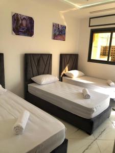 two beds in a hotel room with white sheets at les Belles Résidences de Safir in Tangier