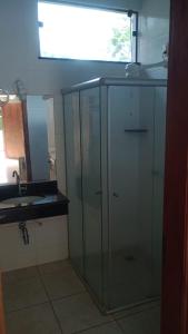 a glass cabinet in a kitchen with a sink at Pousada Aquatur in Presidente Epitácio