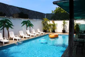 uma piscina com cadeiras e uma jangada na água em D'Cesar Hotel Acapulco em Acapulco