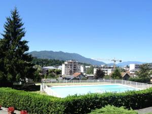 uma piscina com uma cidade ao fundo em Résidence Montcalm D - Studio pour 3 Personnes 704 em Aix-les-Bains