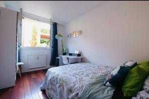 Schlafzimmer mit einem Bett und einem Fenster in der Unterkunft Lovely spacious nest in Ivry in Ivry-sur-Seine