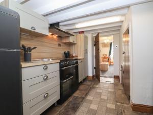a kitchen with white cabinets and a black stove at Wether Fell View in Hawes