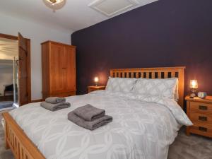 a bedroom with a large bed with two towels on it at Wether Fell View in Hawes