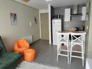 a kitchen with a couch and a table in a room at Coquette Appartement in Boumhel El Bassatine
