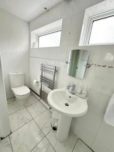 Baño blanco con lavabo y aseo en Pendleton Valley, en Peterborough