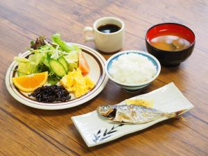 uma mesa com dois pratos de comida e uma tigela de arroz em Shodoshima Olive Youth Hostel em Shodoshima