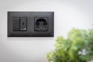 a lightswitch on a wall next to a plant at Urban city apartment in Visoko