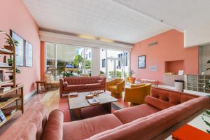Tropics Hotel Miami Beach في ميامي بيتش: غرفة معيشة مع جدران برتقالية وأرائك جلدية