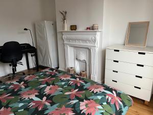 a bedroom with a bed and a dresser and a fireplace at Ilford Hidden Gem in Ilford