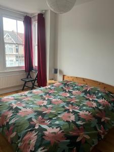 a bedroom with a bed with a floral bedspread at Ilford Hidden Gem in Ilford