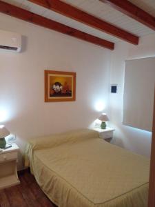 ein Schlafzimmer mit einem Bett und zwei Nachttischen in der Unterkunft Lo de Cacho in Junín