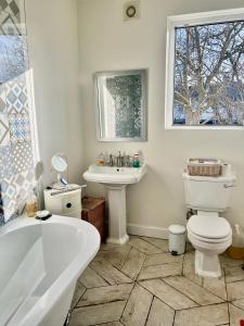 伊爾福德的住宿－Ilford Hidden Gem，带浴缸、卫生间和盥洗盆的浴室