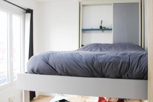 Modern cocoon near Belleville في باريس: سرير جالس على رصيف في غرفة النوم