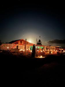 a building with lights in front of it at night at Lobo Hostel Bar in Cabo Polonio