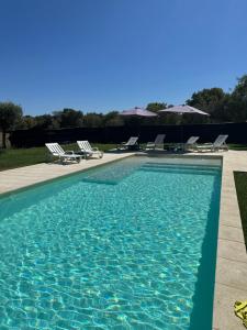 a swimming pool with lounge chairs at Monte das Hortas Velhas in Viana do Alentejo