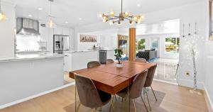 a kitchen and dining room with a wooden table and chairs at New Hidden Gem in Miami