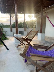 a group of chairs and hammocks on a patio at Casa Delfín Tulum in Macario Gomez