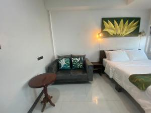a bedroom with a bed and a couch and a chair at Lemon Guesthouse in Chiang Mai