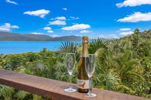a bottle of champagne and two wine glasses on a bench at Kokomo in Airlie Beach
