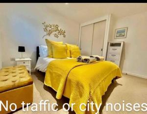 - une chambre avec un lit jaune et une couverture jaune dans l'établissement Gorgeous apartment with free parking & breakfast near city centre & midday checkout, à Bristol