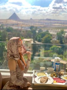 a figurine of a woman sitting at a table with food at WOW Pyramids Inn in Cairo