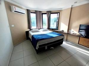 a bedroom with a bed and a desk and a television at Victory Flat in João Pessoa