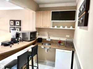 a small kitchen with a sink and a microwave at Victory Flat in João Pessoa