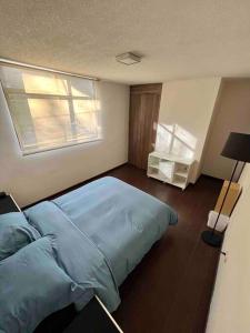 una camera con un letto blu e una finestra di Oasis 101 a El Gallinero