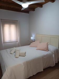 1 dormitorio con 1 cama blanca grande y 2 toallas en La casita Ronda en Ronda