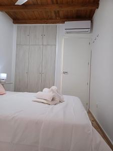Una cama blanca con toallas en una habitación en La casita Ronda, en Ronda