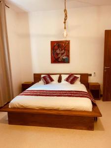 a bedroom with a large bed with white sheets and red pillows at Oxygen Paje Hotel in Paje
