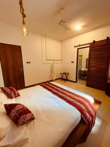 a bedroom with a large bed with two pillows on it at Oxygen Paje Hotel in Paje