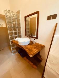 a bathroom with a sink and a mirror on a counter at Oxygen Paje Hotel in Paje