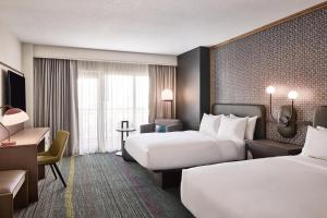 グレンデールにあるルネッサンス フェニックス グレンデール ホテル ＆ スパのベッド2台とデスクが備わるホテルルームです。