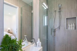 a bathroom with a shower and a sink at Hillside Villa 3- Walk To Town- AC- Free Parking in Queenstown +6 photos