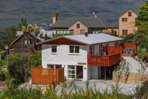 a house with a balcony in front of a house at Hillside Villa 3- Walk To Town- AC- Free Parking in Queenstown
