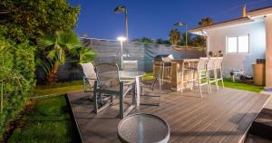 マイアミにあるStriking Urban Villa Backyard BBQ Fire Pit Poolのデッキにテーブルと椅子が置かれたパティオ