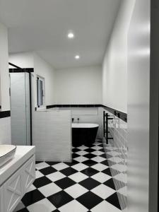 een badkamer met een zwart-wit geruite vloer bij Rare Broulee beachfront house in Broulee