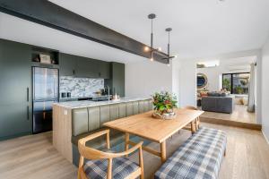 een keuken en een woonkamer met een houten tafel bij Karearea- AC- Free Parking- BBQ- Hot Tub in Queenstown