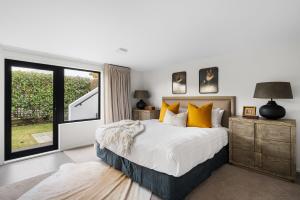 een slaapkamer met een groot bed en een groot raam bij Karearea- AC- Free Parking- BBQ- Hot Tub in Queenstown