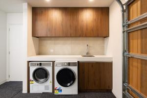 eine Waschküche mit Waschmaschine und Trockner in der Unterkunft Lakehouse 1- Free Parking- Walk To Town- Air Con in Queenstown