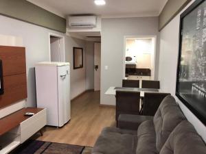 a living room with a couch and a kitchen at Flat mobiliado em Campinas - Ap 124 L Hirondelle in Campinas