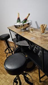 - une table avec 2 bouteilles de vin et 2 verres dans l'établissement Vintage Apartment NEU, à Unterentfelden