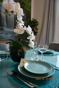 uma mesa com um prato e um vaso com flores brancas em Apartment near Old Town em Cracóvia
