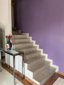 una escalera con una mesa de cristal y un jarrón en Apartamento em Linhares LocalTOP, en Linhares