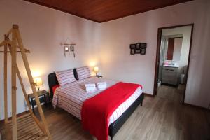a bedroom with a bed with a red blanket at Casas da Biquinha in Sintra