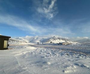 uma estrada coberta de neve com montanhas ao fundo em REY Stays - Small & Cozy Studio em Höfn