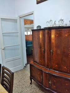 a large wooden cabinet in a room with a door at La Dorada , Casa entera en Excelente Zona Residencial con cochera techada in Rosario +15 photos