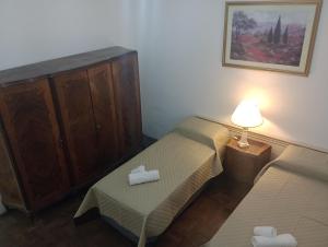 - une petite chambre avec deux lits et une lampe dans l'établissement La Dorada con cochera techada, à Rosario