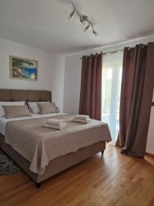 a bedroom with a large bed with brown curtains at Villa JaNi in Donja Jagodnja